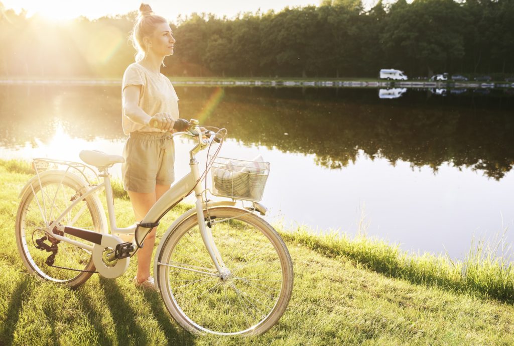 Woman with bike by the lake